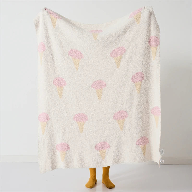 Ice cream pattern blanket held upright, showing its full cream surface and repeating pink cone print