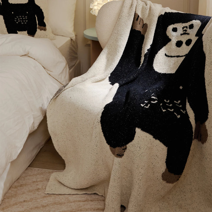 Ivory throw blanket with a large black cartoon gorilla design