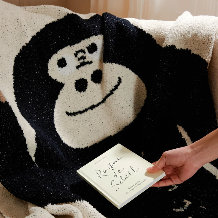 Close-up of an ivory blanket with a black and white cartoon gorilla