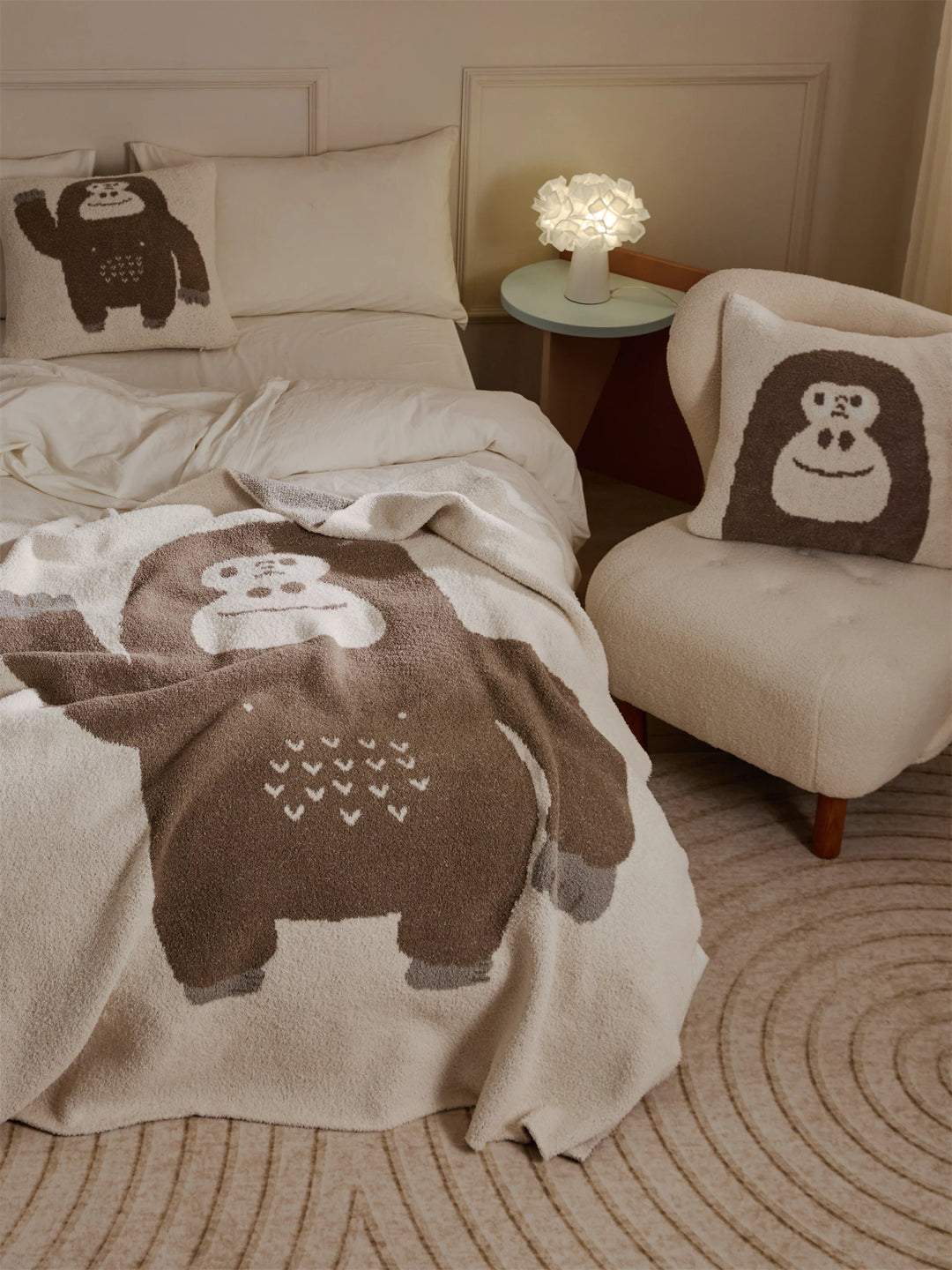 Ivory throw blanket featuring a large brown cartoon gorilla design