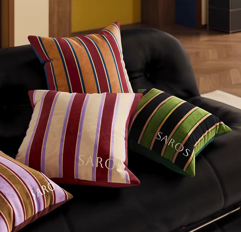 Striped scatter pillows in orange, red, green, black, pink, and cream, in square and bolster shapes