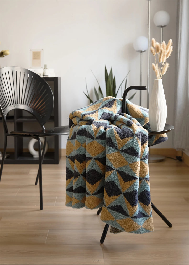 Geometric blanket draped over a chair with its triangle pattern visible.