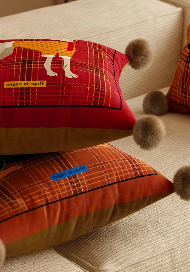 Red and brown plaid dog pillows with pom-pom corners, shown from the side