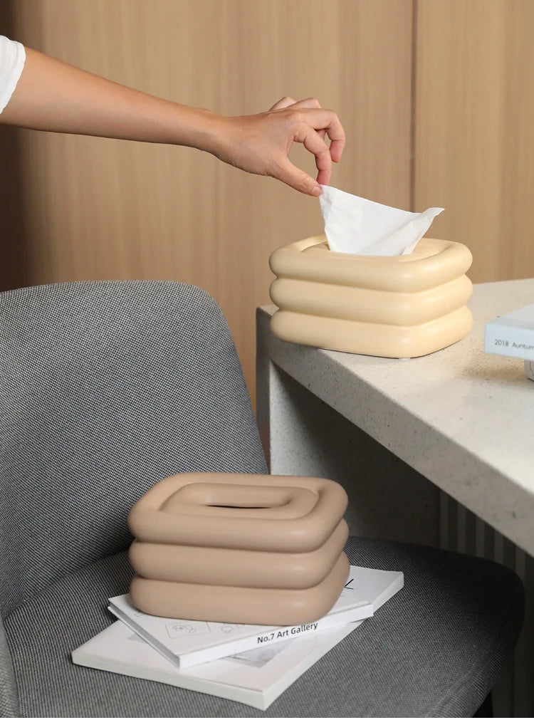 Creamy yellow and light brown square tissue holders with rounded stacked sides.