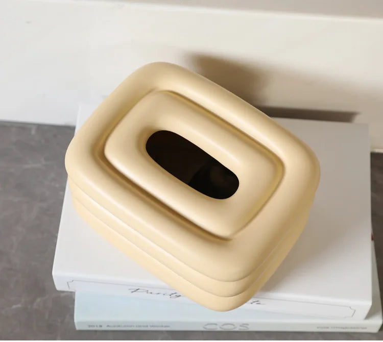 Creamy yellow square tissue holder with rounded edges and a centered oval tissue opening