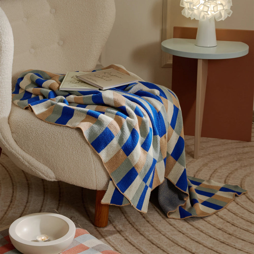 Blue striped knitted blanket draped over a chair