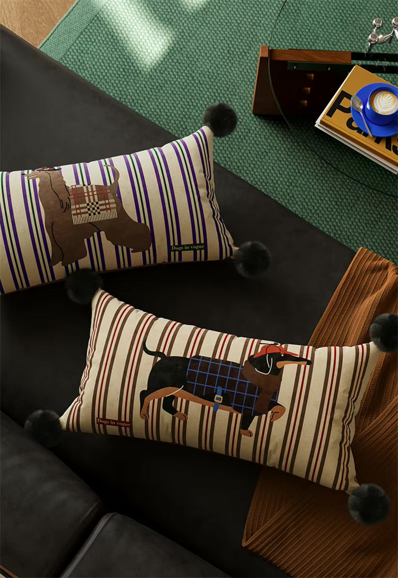 Two striped dog-print lumbar pillows with black pom-pom corners, viewed from above