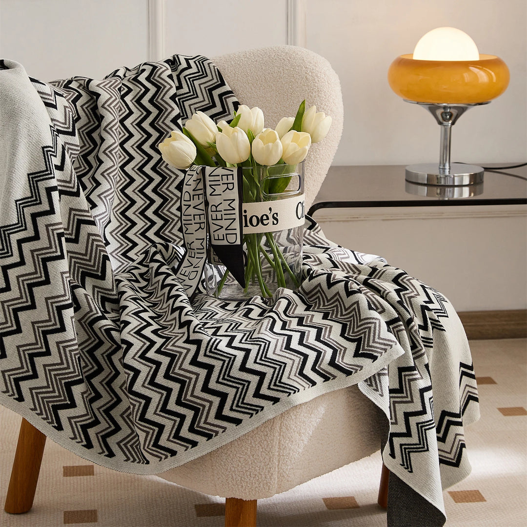 Black and cream wave stripe blanket draped over an armchair