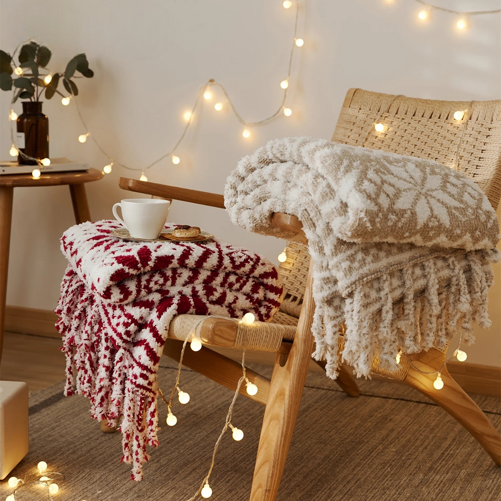 Wine and beige patterned knit throw blankets with fringes displayed on chairs