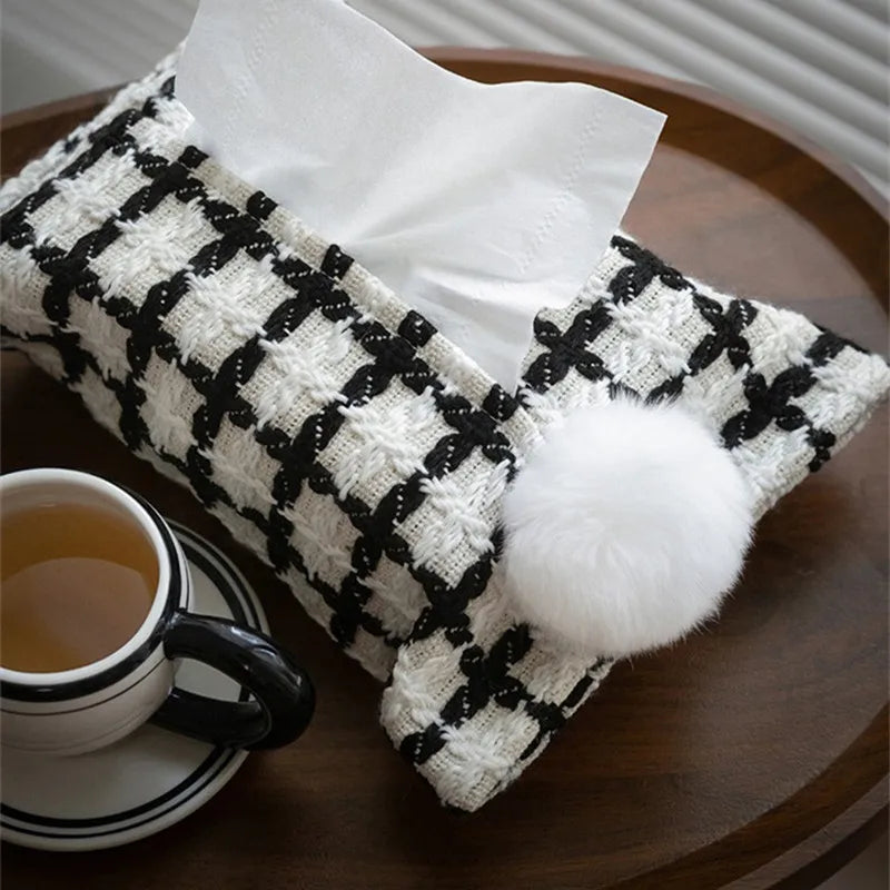 Black and white woven tissue holder with checker pattern and white pom-pom