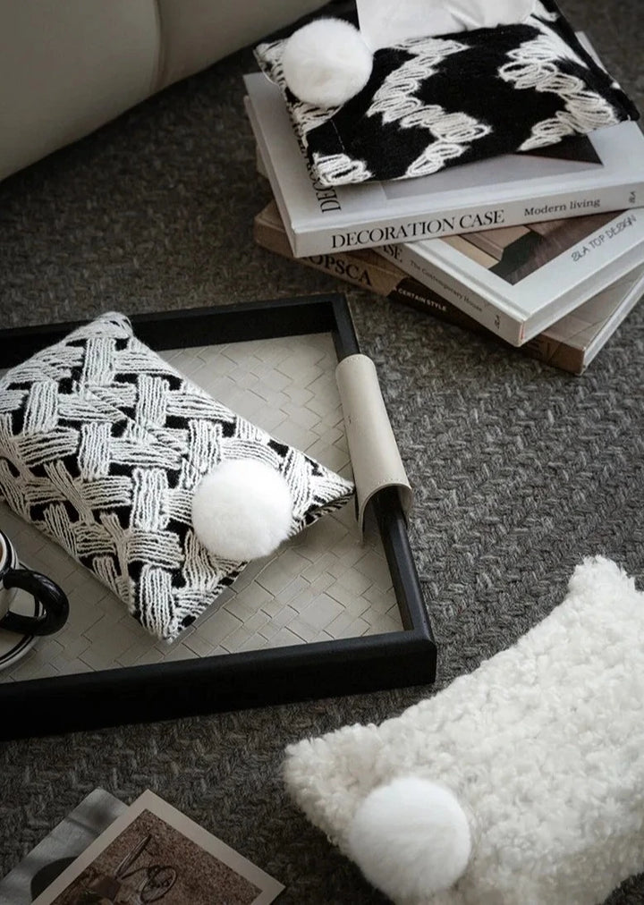 Woven tissue holders with white pom-poms in black and white patterns