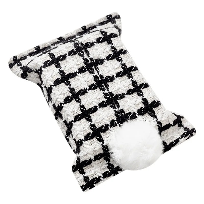 White tissue pouch with a black grid and white bunny-tail pom-pom.