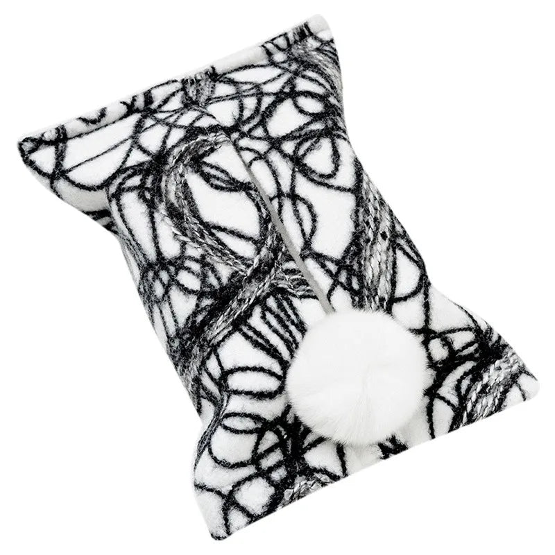 White tissue pouch with black abstract loops and a white bunny-tail pom-pom.