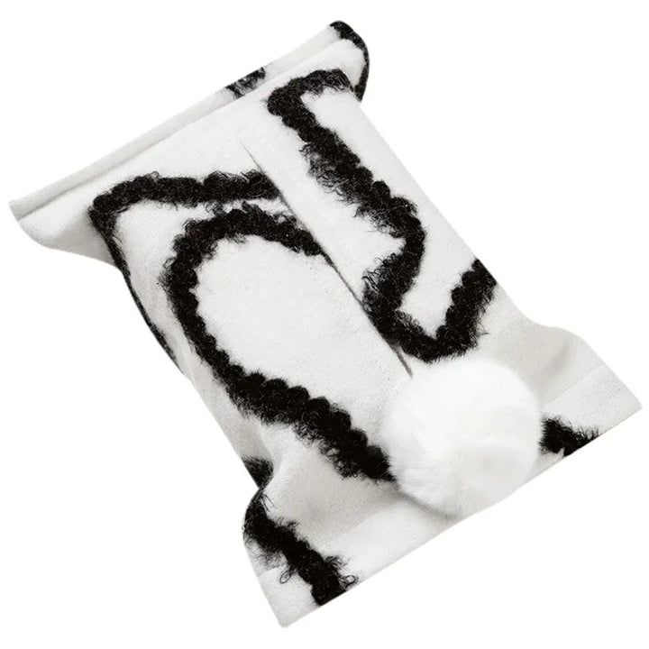 White tissue pouch with black wavy lines and a white bunny-tail pom-pom.