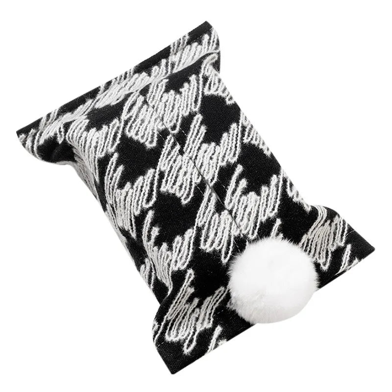 Black and white houndstooth tissue pouch with a white bunny-tail pom-pom.