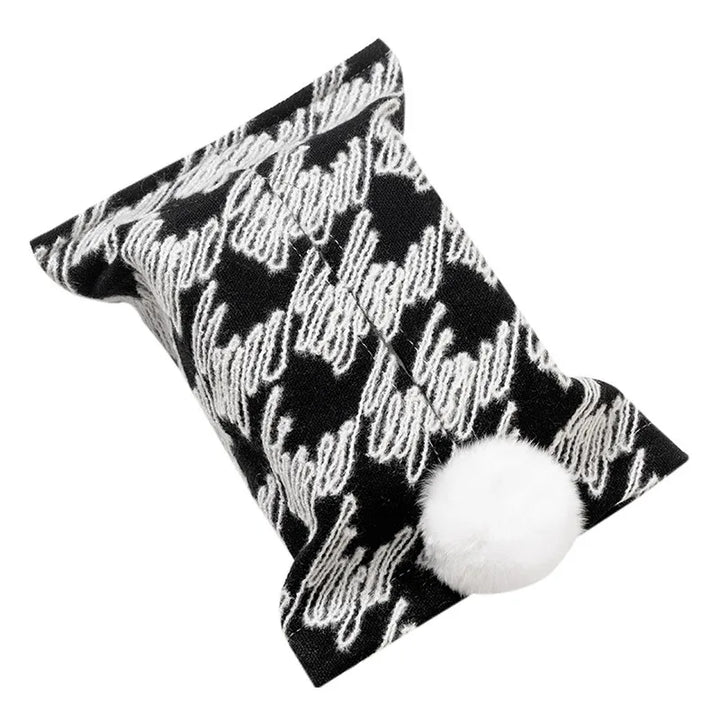 Black and white houndstooth tissue pouch with a white bunny-tail pom-pom.