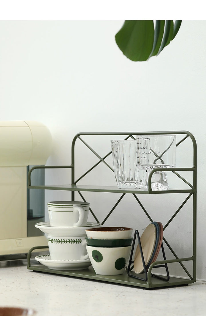 A side view of a green metal shelf with some glass and cups on two levels.
