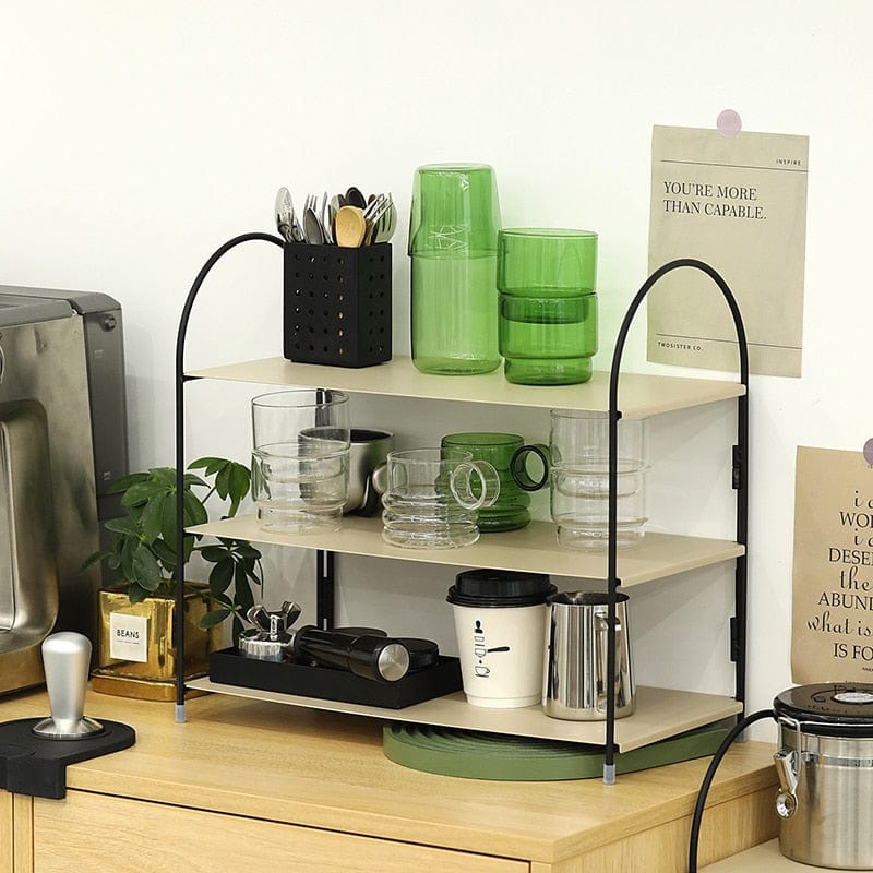 A three layer foldable metal shelf stand with some kitchen items placed on all levels.